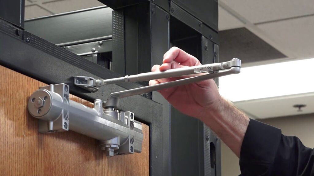 Locksmith Raleigh technician adjusting door closer speed settings during commercial repair in Raleigh NC