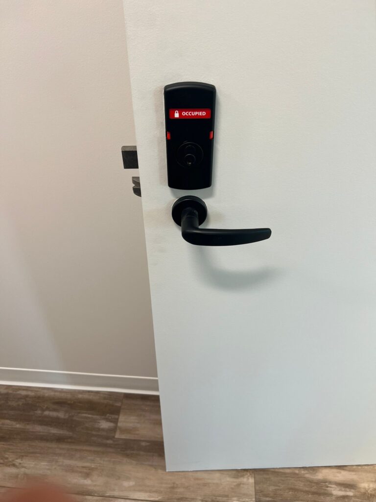 Locksmith Raleigh technician configuring a new smart lock via mobile app for a Raleigh homeowner