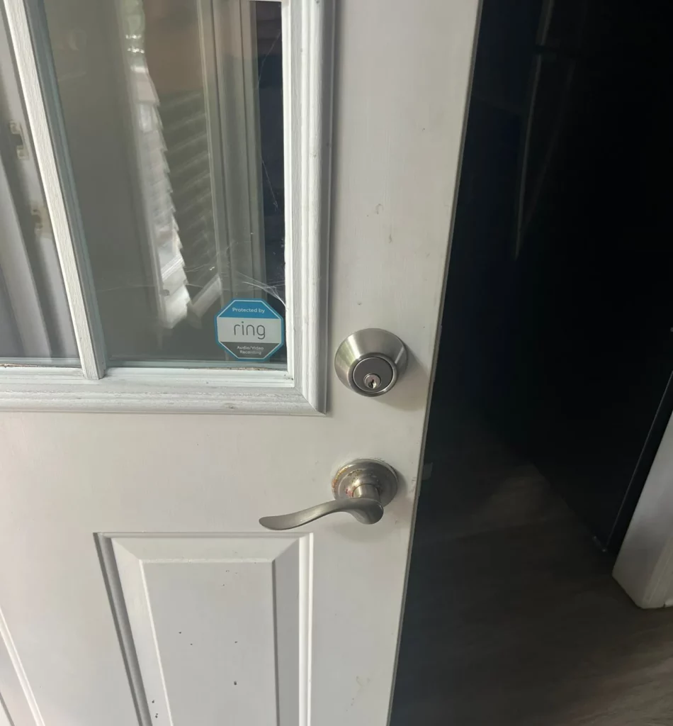 Locksmith repairing a deadbolt lock on a commercial metal door in Raleigh NC