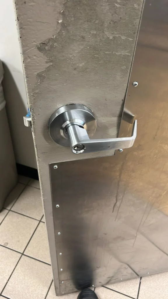 Locksmith Raleigh technician installing a commercial mortise lock on a business entry door in Raleigh North Carolina