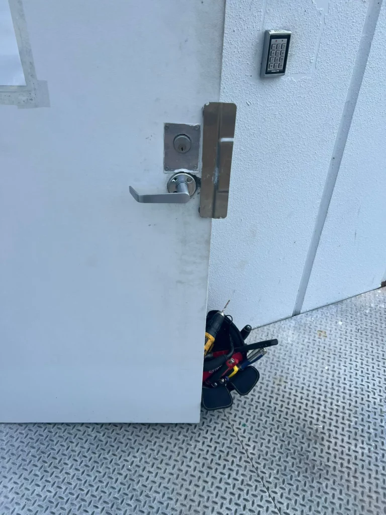 Locksmith Raleigh technician repairing internal components of a mortise lock in a commercial door in Raleigh NC