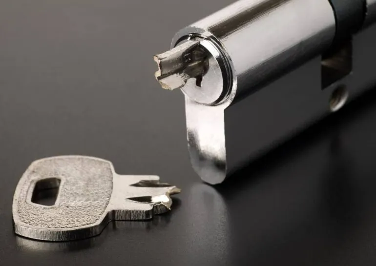 Close-up of a broken key lodged inside a metal lock cylinder.