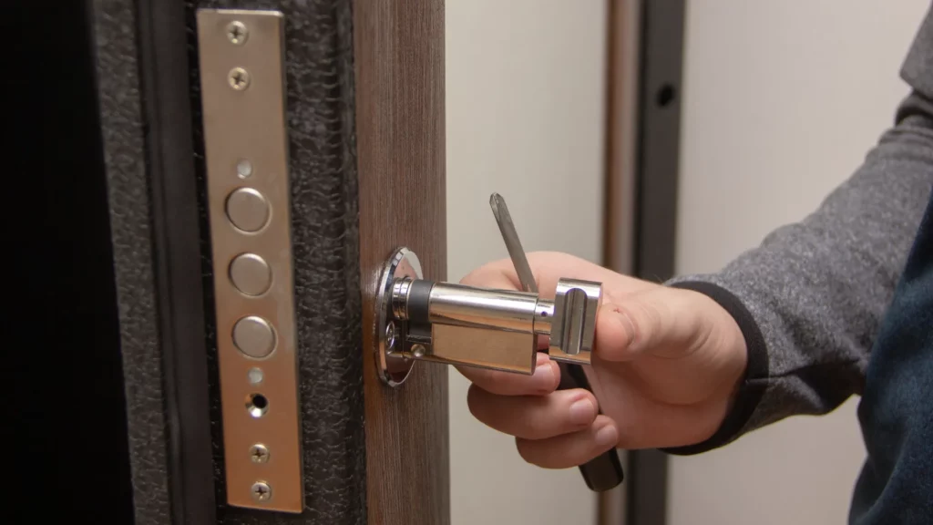 Locksmith Raleigh technician removing a broken key from a residential door lock in Raleigh North Carolina